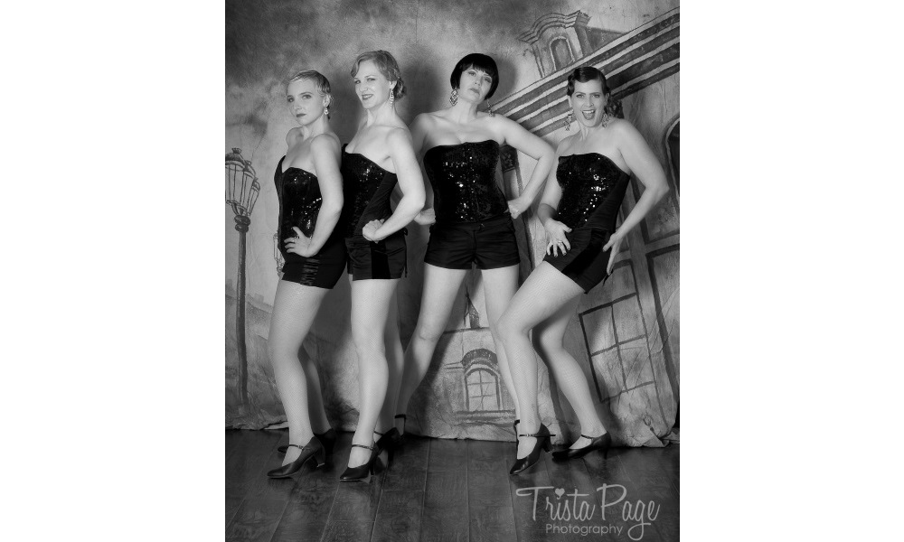 The Charleens posing in sequin costumes with a city backdrop.