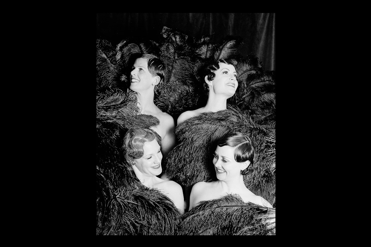 The Charleens dance troupe posing with black ostrich feather fans.