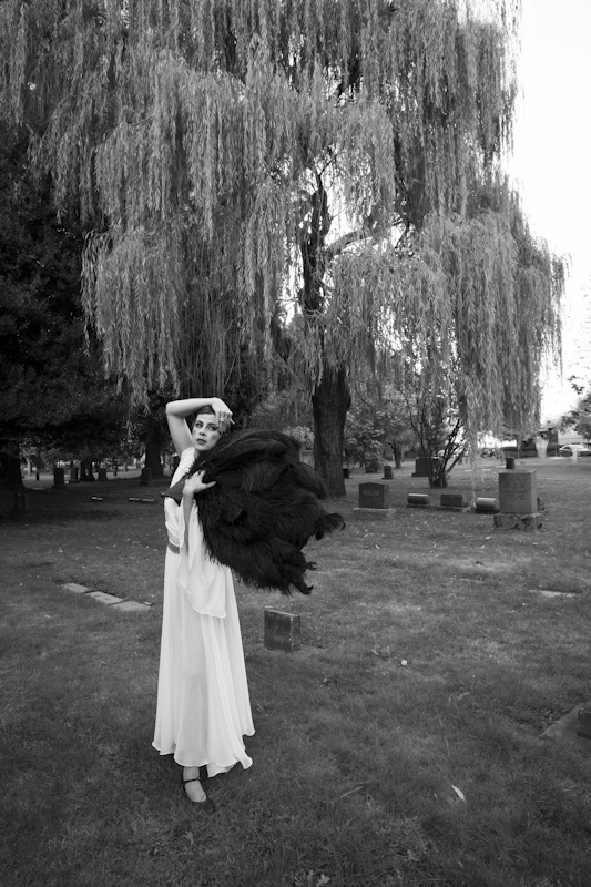 woman standing with black fans in the cemetery